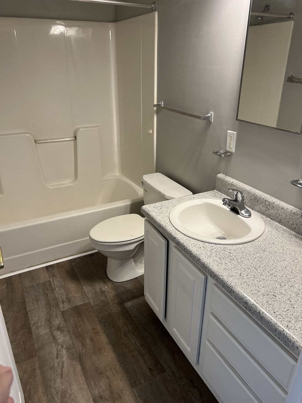A white toilet sits next to a sink in a bathroom.