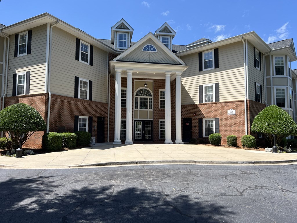 A large, two-story building with a front porch and a covered entrance.