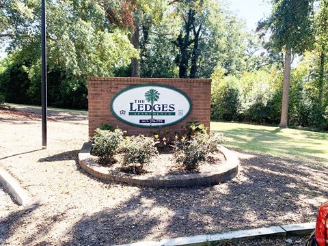 A sign that says "The Ledges" is in front of a grassy area.