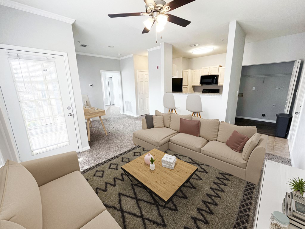 A living room with a beige couch and a coffee table.