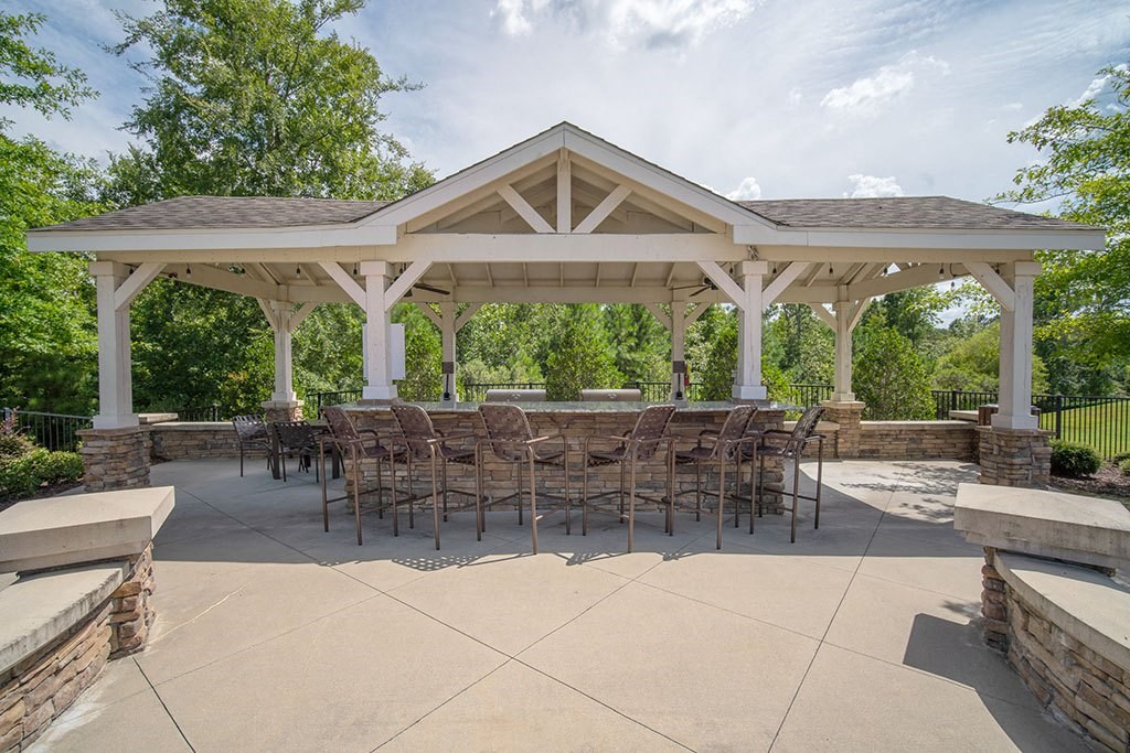 a large patio with a table and chairs under a pavilion