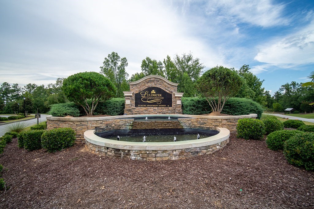 a fountain in a park with a sign