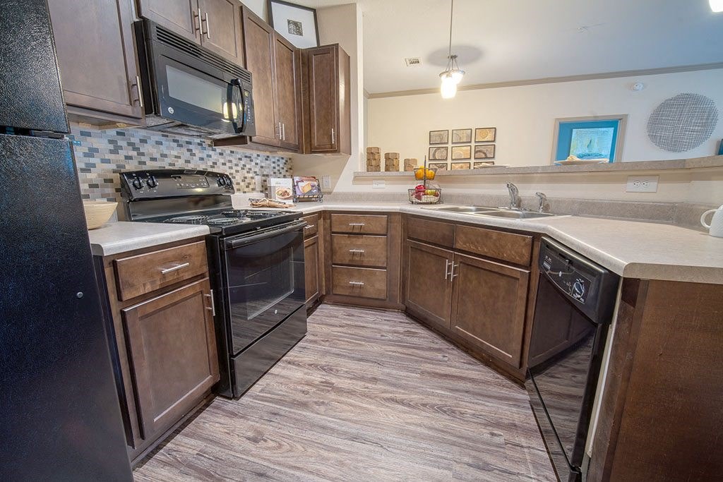 a kitchen with wooden cabinets and black appliances