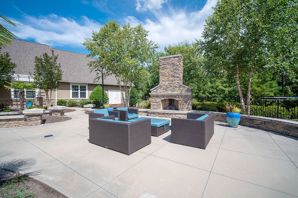 a large patio with furniture and a stone fireplace