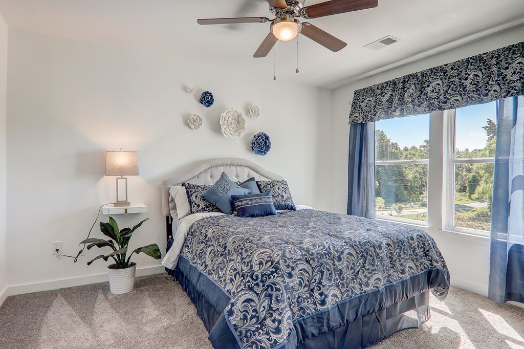 3 Bedroom Townhomes In Greenville, SC - Marbella Townhomes - A Bedroom With A Large Bed, White Comforter, Blue Accents, A Window, And Modern Rustic Charm.