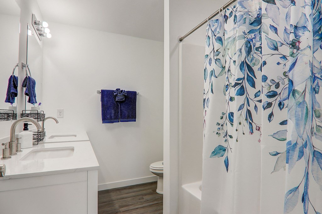 a bathroom with a shower curtain and a sink and a toilet