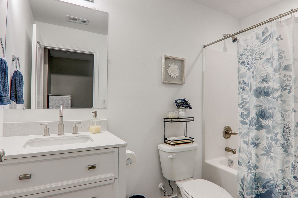 a white bathroom with a shower and a sink and a toilet