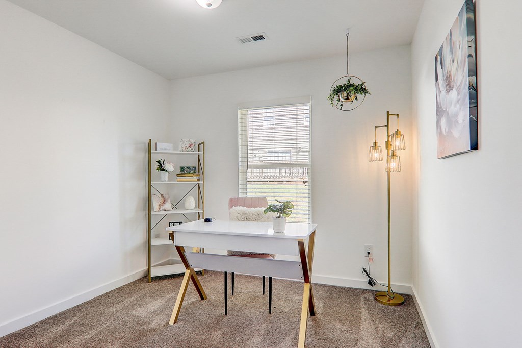 a home office with a white desk and a window