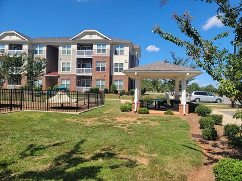 A large apartment complex with a gazebo in the front yard.