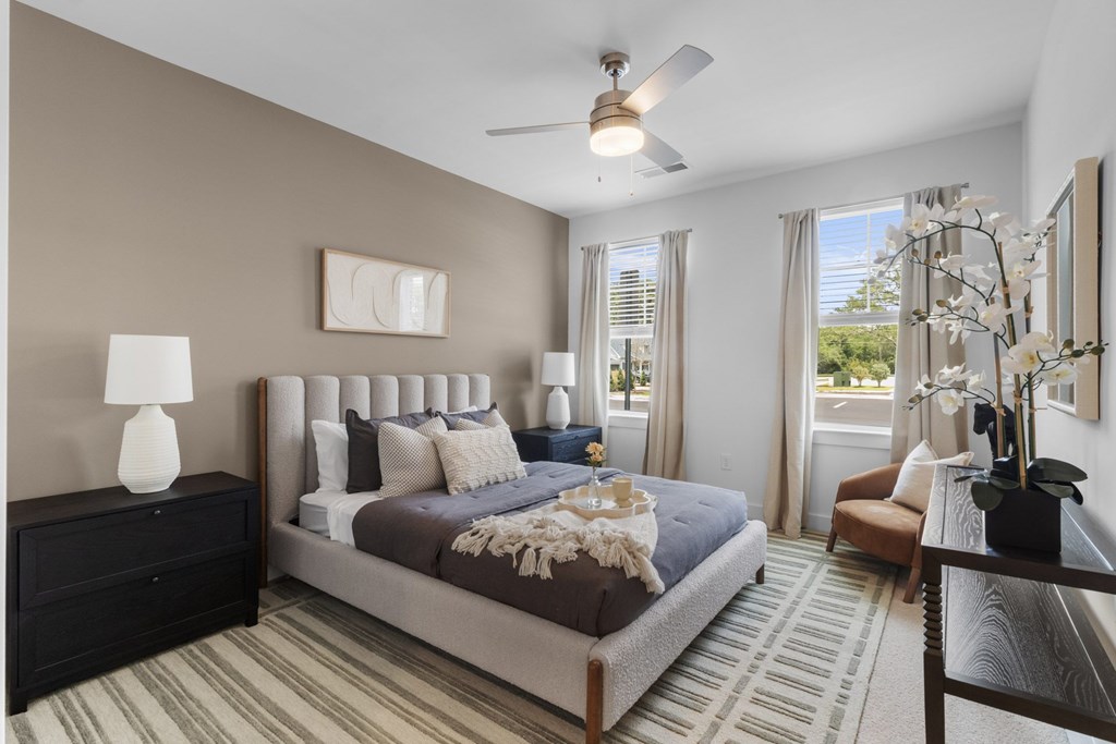 A bedroom with a large bed and a ceiling fan.