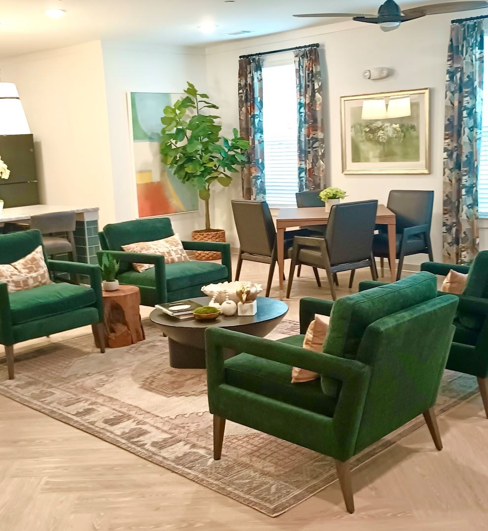 Ovata at Reedy Creek community room with green chairs and a wooden coffee table.