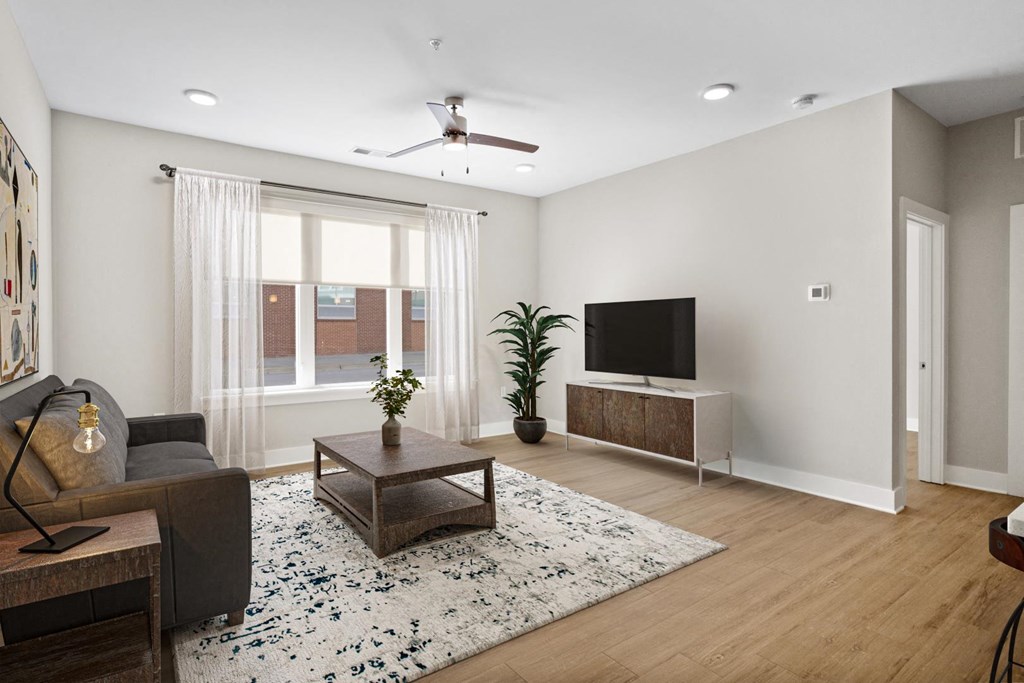 Model unit in Park View Greer Apartments in Greer, SC. It features a couch, coffee table, carpet, and LVT flooring.