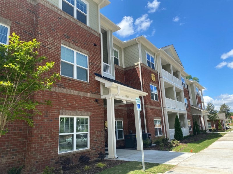 A row of townhouses with a blue sign in front.
