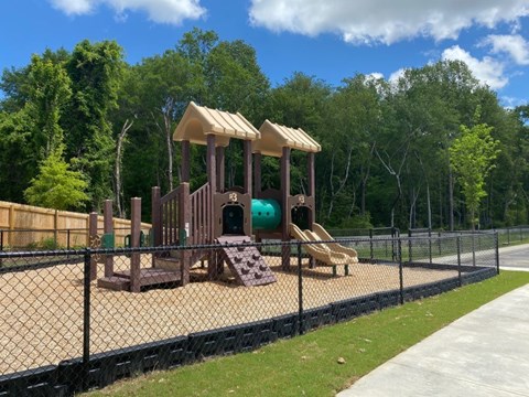 A playground with a slide and a wooden structure.