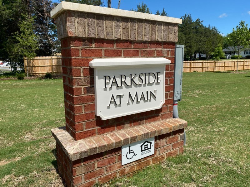 A brick pillar with a sign that says Parkside at Main.
