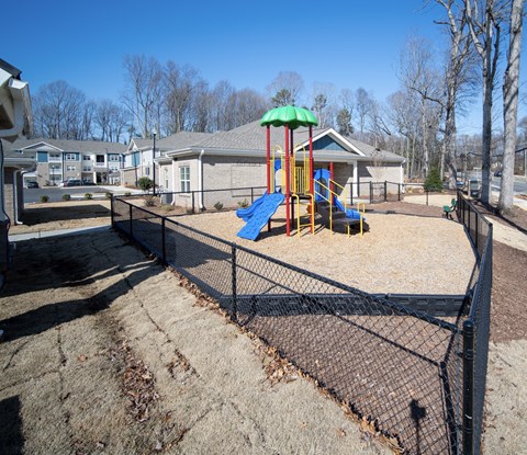 A playground with a blue slide and a green canopy.
