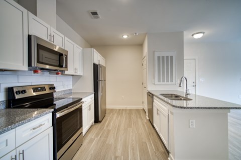 A kitchen with white cabinets and black appliances.