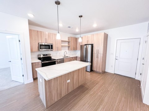 A kitchen with wooden cabinets and a white island.