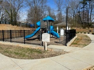 A playground with a blue slide and a sign.