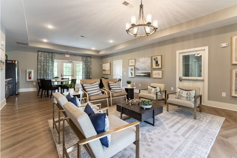 A well-lit living room with a variety of seating options and a chandelier.