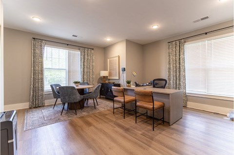 A well-lit room with a dining table and chairs.