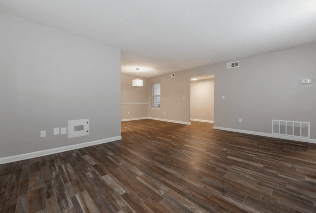 A room with wooden flooring and white walls.