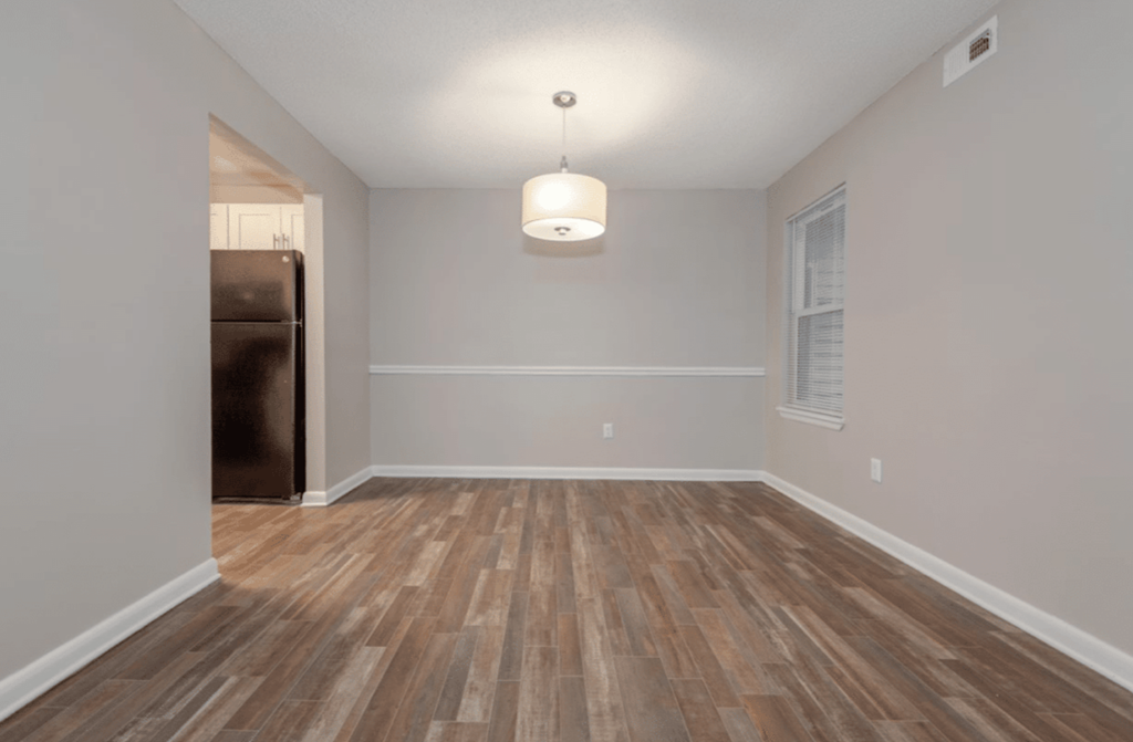 A room with wooden flooring and a light fixture on the ceiling.