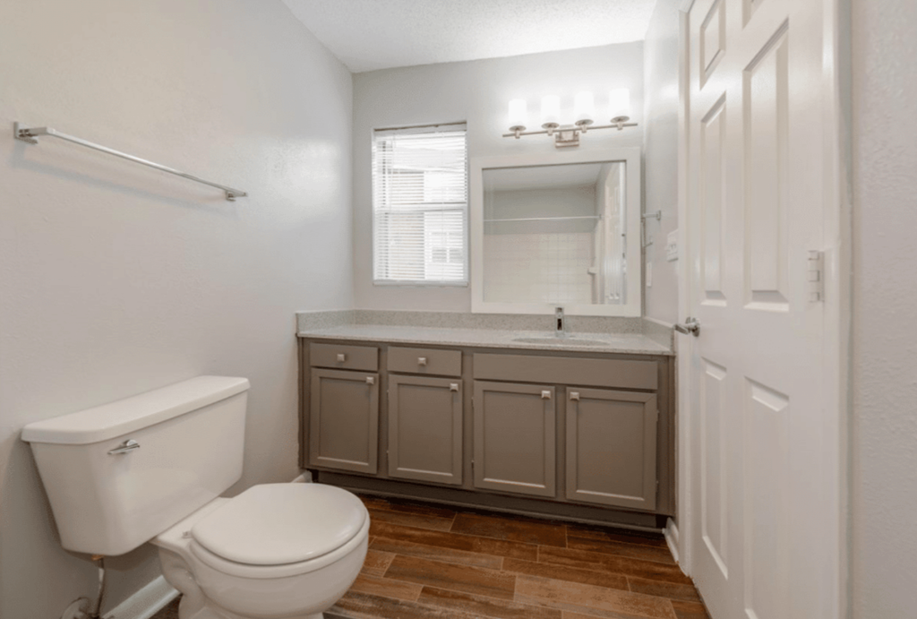 A white toilet sits next to a sink in a small bathroom.