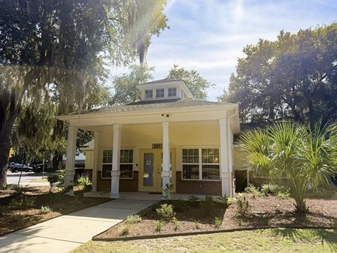 A small white building with a porch and a sign that reads 827.