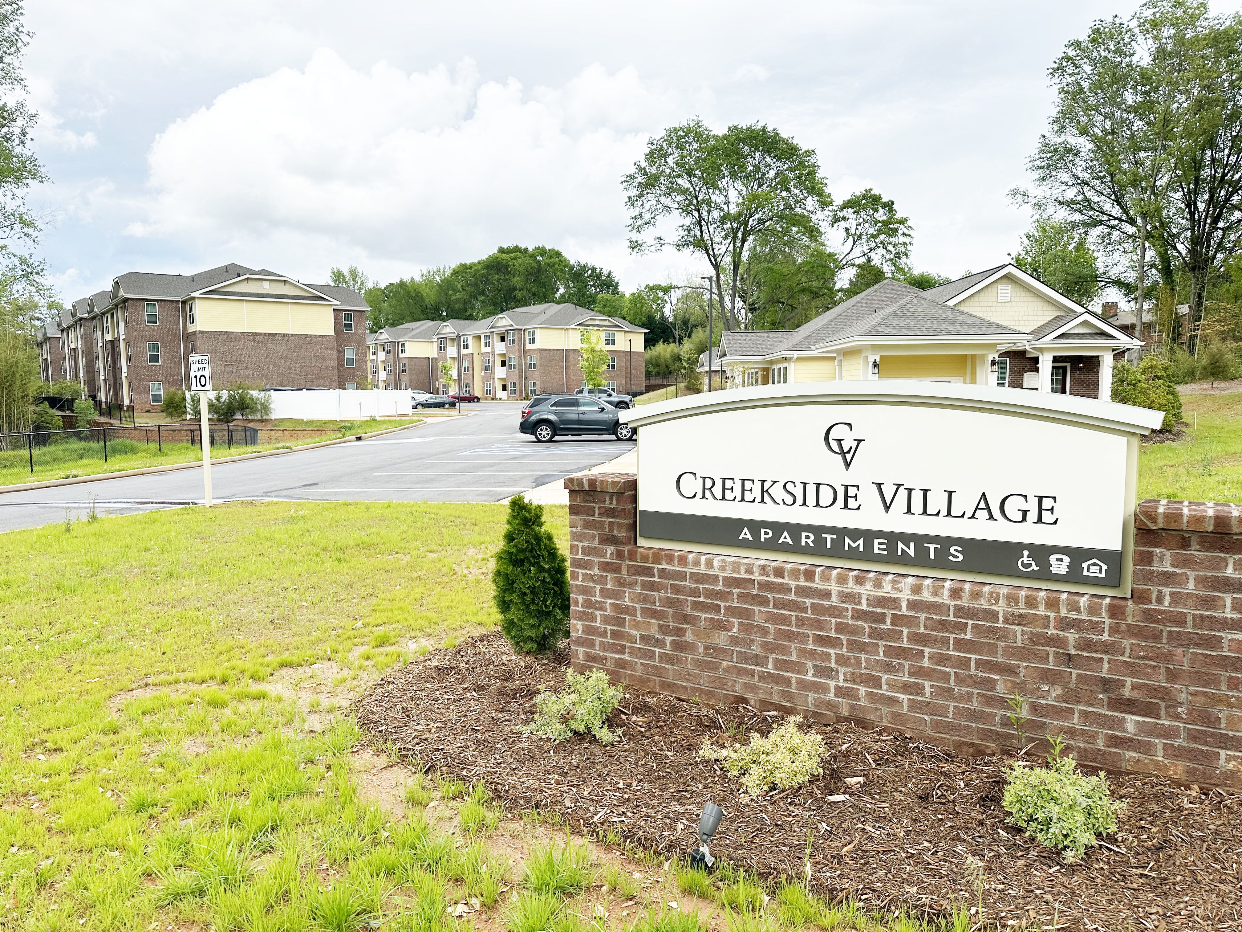 Creekside Village monument sign, with the property name, in front of the apartment community