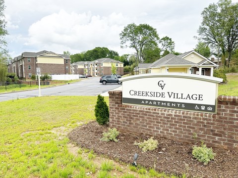 Creekside Village monument sign, with the property name, in front of the apartment community