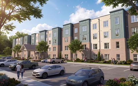 A row of modern townhouses with cars parked in front.