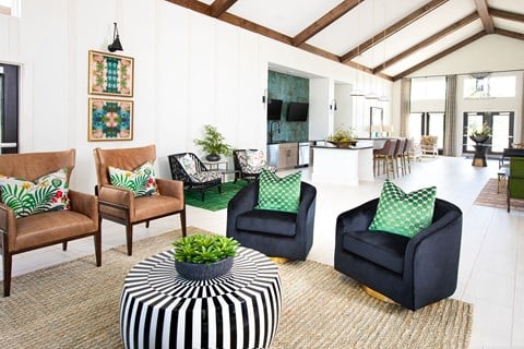 a living room with black and white chairs and a striped ottoman