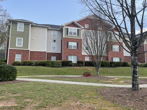 an apartment building with a sidewalk in front of it