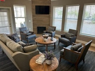 A living room with a fireplace and a flat screen TV mounted above it.