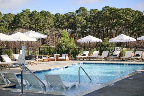 Calabash, NC Pet-Friendly Apartments | The View at Crow Creek | Resort-Style Pool with Sundeck, Lounge Chairs, and Umbrellas.