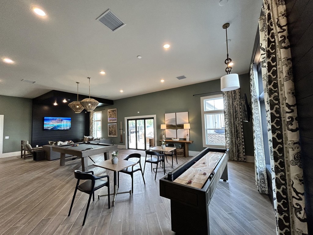 a clubhouse with tables and chairs and a bar and a tv