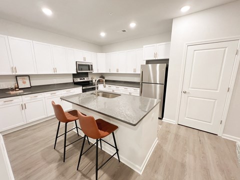 A kitchen with white cabinets and a black countertop.