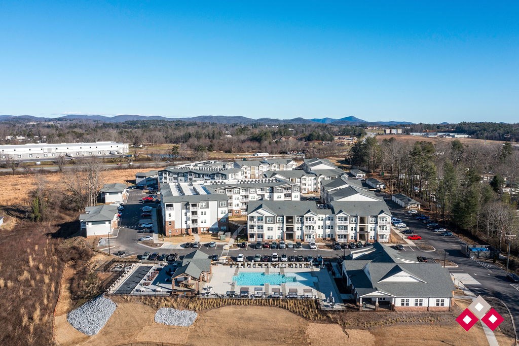A large resort with a swimming pool and a parking lot.