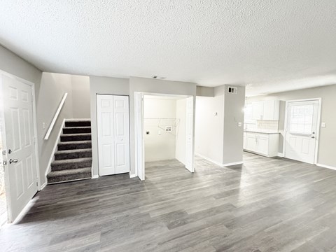 Reserve at Hillcrest living room with LVT flooring, washer and dryer hookups, bathroom, kitchen, closet and carpeted stairs.