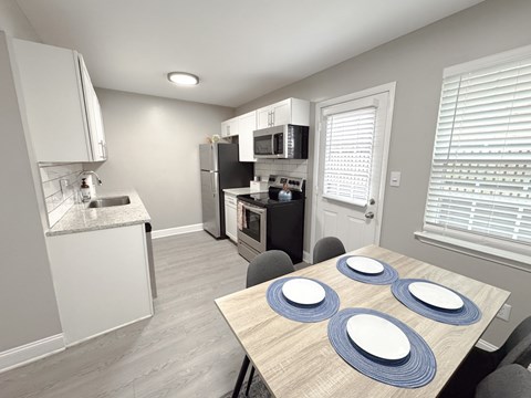 A kitchen with a table set for four.