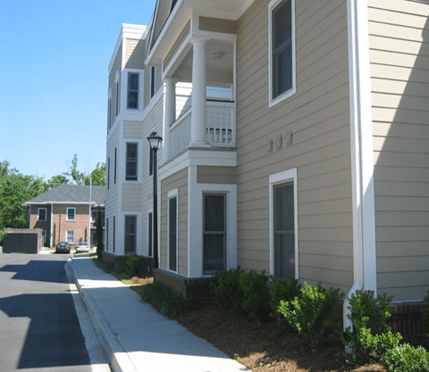 a street view of an apartment building with a sidewalk