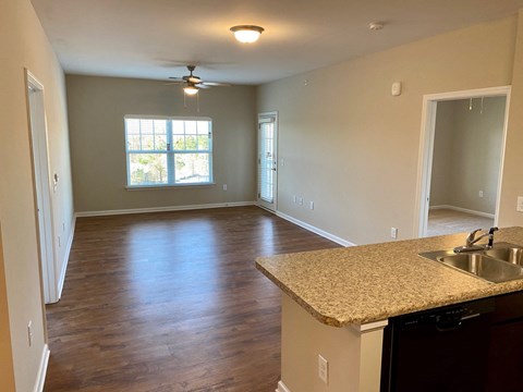 an empty kitchen and living room with a large window
