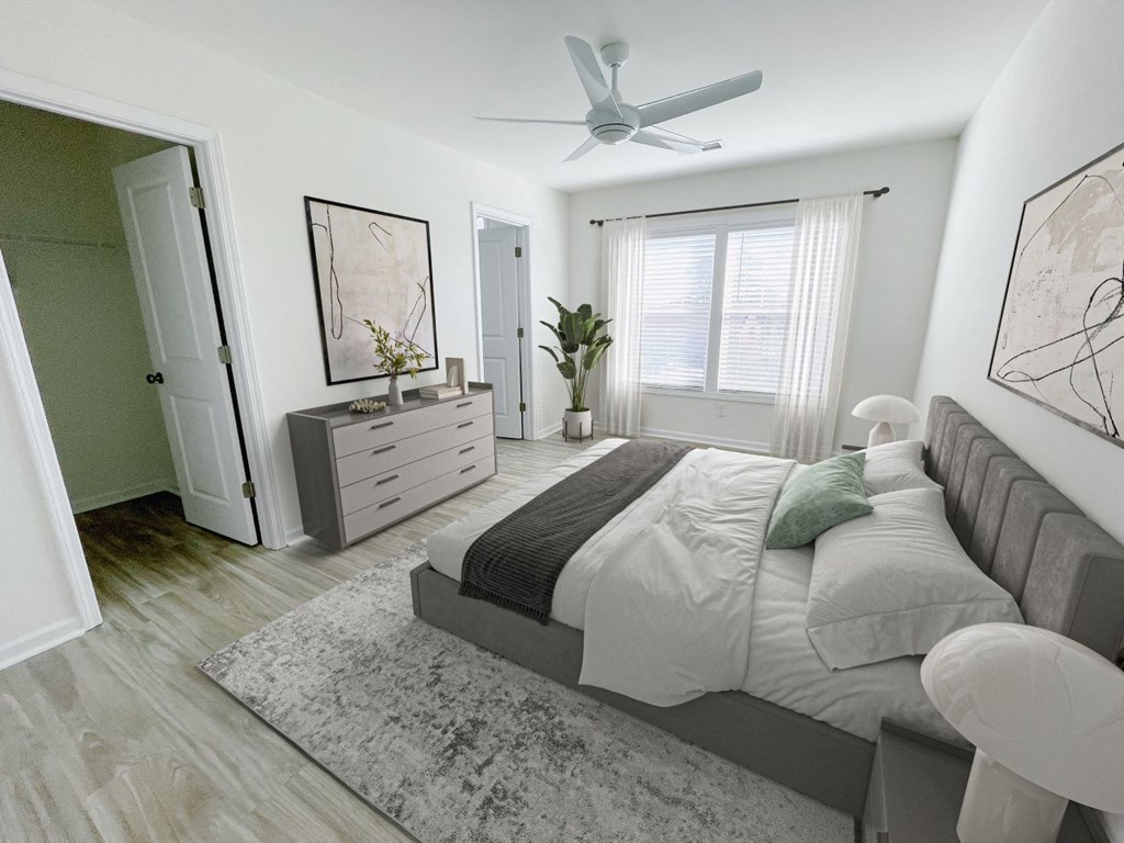 A bedroom with a large bed, a dresser, and a ceiling fan.