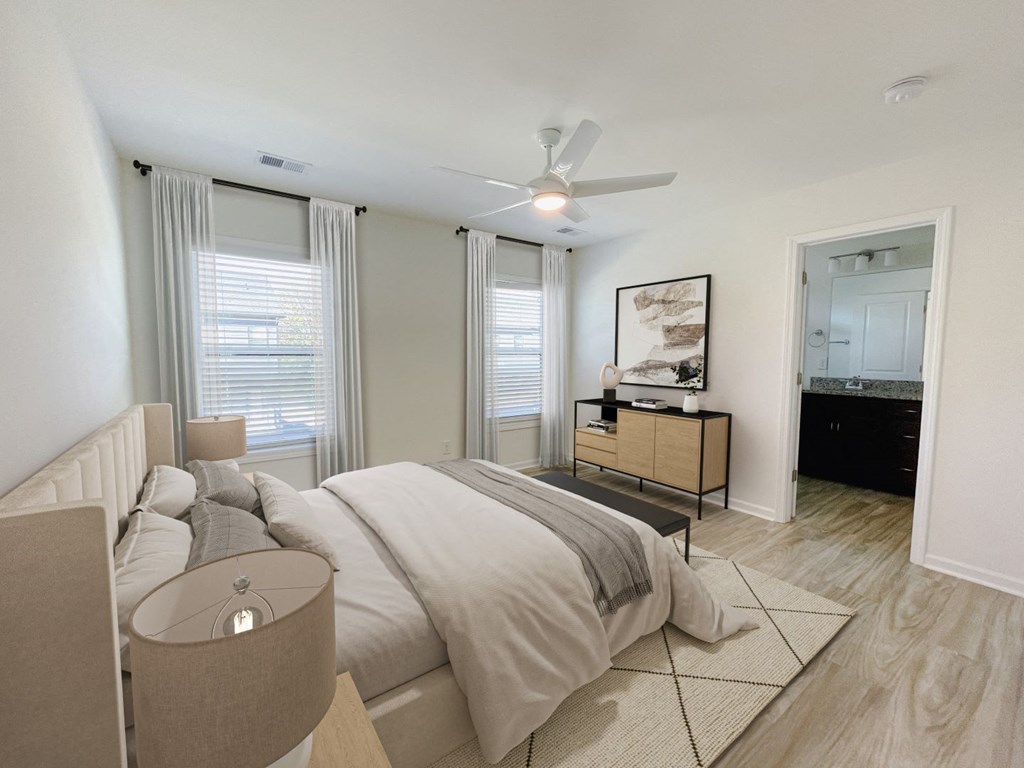 A bedroom with a large bed and a ceiling fan.