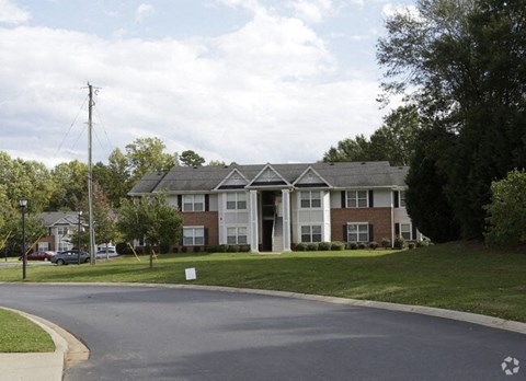 A residential building with a driveway in front.