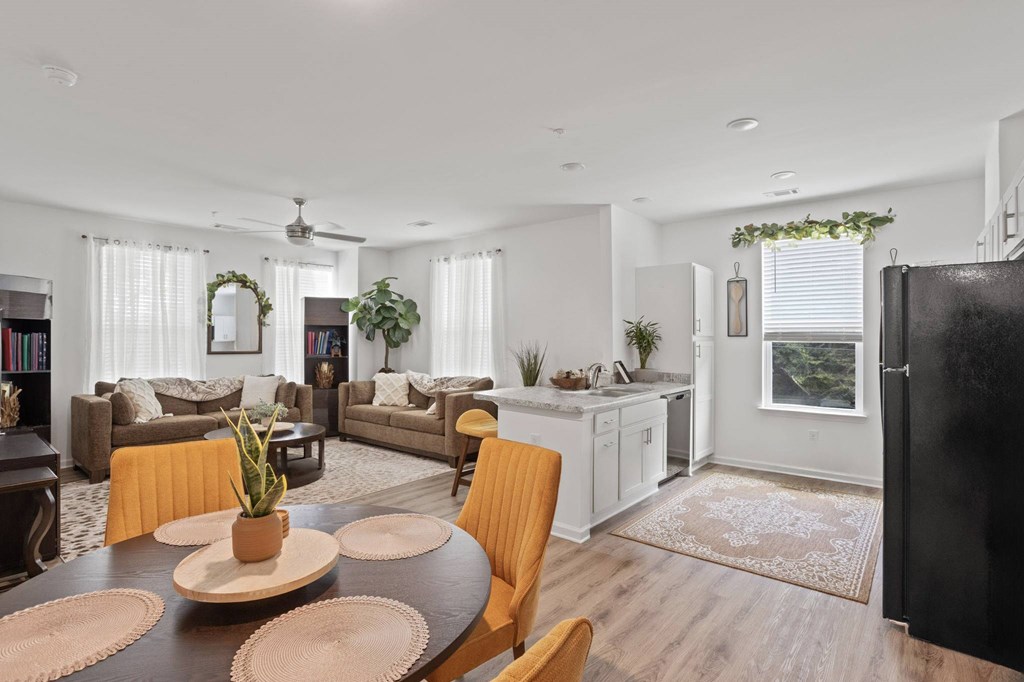Ovata at Reedy Creek kitchen, dining room and living room with LVT, modern appliances and a ceiling fan.