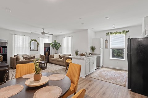 A modern living room with a dining table set in the center.