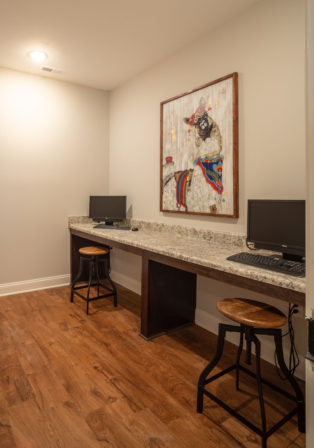 A room with a desk and a painting on the wall.
