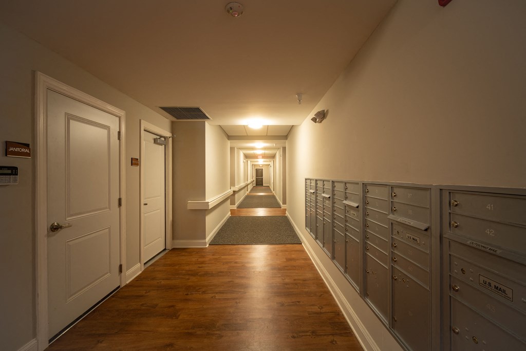 A long hallway with mailboxes on the wall.